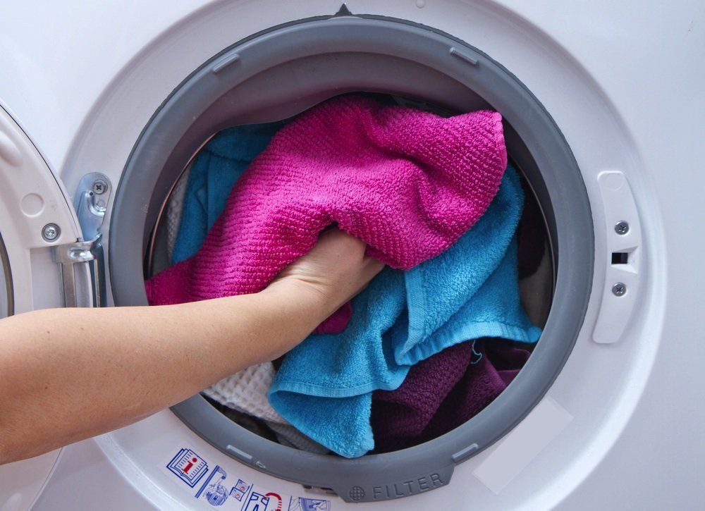 Towels being put inside a dryer